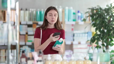 Woman in pharmacy scans QR code on mouthwash Stock Footage 325766746