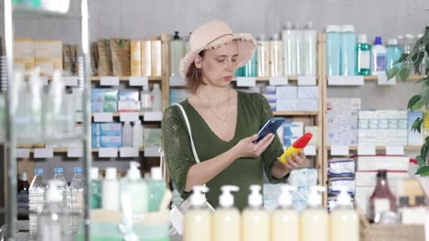 Woman in pharmacy scans QR code on mosquito repellent Vidéo 326309261
