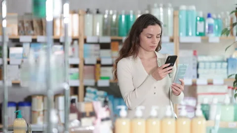 Woman in pharmacy scans QR code on cream product Stock Footage 326314898