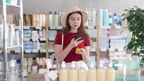 Woman in pharmacy scans QR code on insect repellent Vidéo 327130957