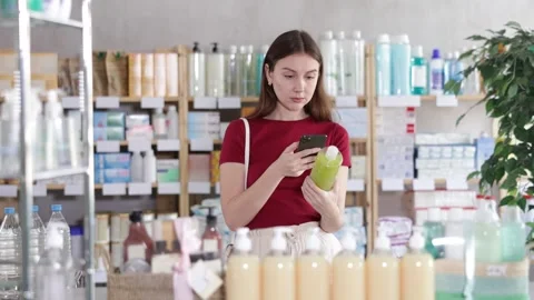 Woman in pharmacy scans QR code on antidandruff shampoo Stock Footage 330402482