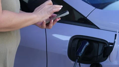Woman on the phone checking electrical charging Stock Footage 278843780