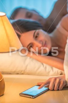 The woman with a phone lay near the man. Evening night time Stock Photos