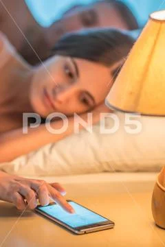 The woman with a phone lie near the man. Evening night time Stock Photos