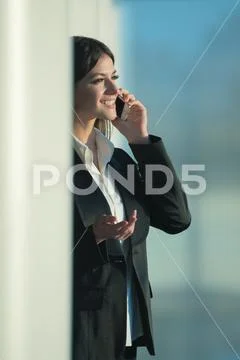 The woman phone over the column Stock Photos