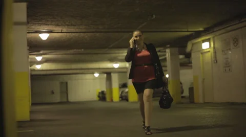 Woman on Phone Walking Through Empty Parking Garage, Dolly Stock-Footage 33756540