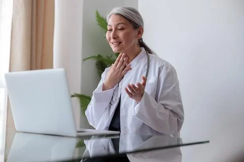 Woman physician consulting a patient via video call Stock Photos