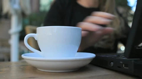 Woman picking up cup of coffe while working on a laptop Stock-Footage 2985984