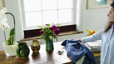 Woman picking up jacket and keys Stock Footage