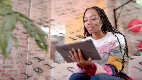 Woman picking up tablet and presenting in loft living room, binary overlay Stock Footage 333873267