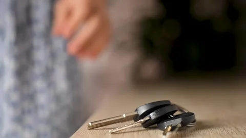 Woman picks up keys from table, close-up. Female hand taking car keys while.. Stock Footage 296046534