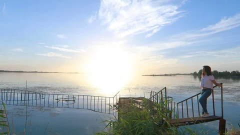 Woman at the pier by the river Stock Footage 84589724