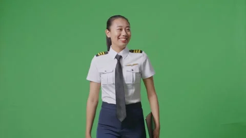 Woman Pilot Holding A Tablet While Walking In The Green Screen Background Studio Stock Footage 251685263