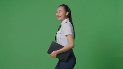 Woman Pilot Holding A Tablet While Walking In The Green Screen Background Studio Stock Footage 251686644