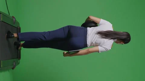 Woman Pilot Holding A Tablet While Walking On Treadmill In The Green Screen Stock Footage 251687369