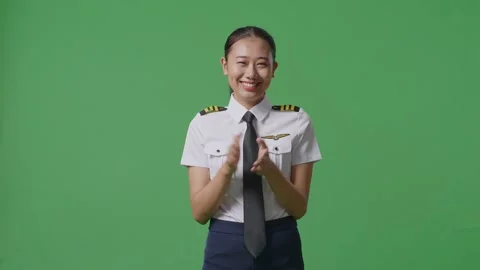 Woman Pilot Smiling And Clapping Her Hands While Standing In The Green Screen Stock Footage 251641138