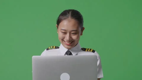 Woman Pilot Smiling And Using A Laptop While Standing In The Green Screen Stock Footage 251643842