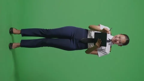 Woman Pilot Taking Note On A Tablet While Standing On Green Screen Background Stock Footage 251645655