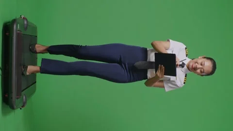 Woman Pilot Taking Note On A Tablet While Walking On Treadmill On Green Screen Stock Footage 251686035
