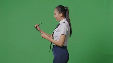 Woman Pilot Taking Note On A Tablet While Walking In The Green Screen Background Stock Footage 251686615