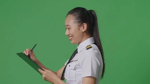 Woman Pilot Taking Note On A Tablet While Walking In The Green Screen Background Stock Footage 251686905