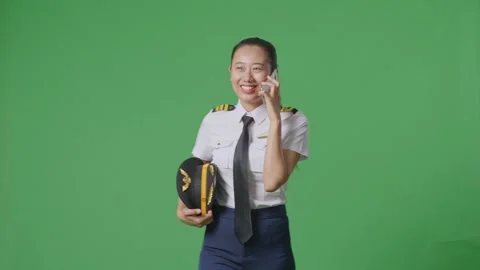 Woman Pilot Talking On Smartphone While Walking In The Green Screen Background Stock Footage 251685141
