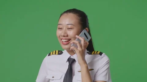 Woman Pilot Talking On Smartphone While Walking In The Green Screen Background Stock Footage 251685642