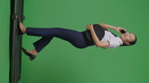 Woman Pilot Talking On Smartphone While Walking On Treadmill In The Green Screen Stock Footage 251686369