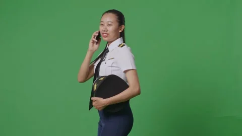 Woman Pilot Talking On Smartphone While Walking In The Green Screen Background Stock Footage 251686581