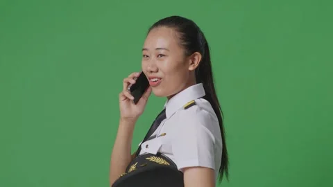 Woman Pilot Talking On Smartphone While Walking In The Green Screen Background Stock Footage 251686818