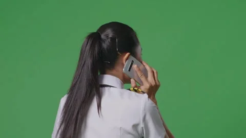 Woman Pilot Talking On Smartphone While Walking In The Green Screen Background Stock Footage 251686993