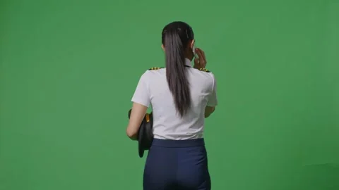Woman Pilot Talking On Smartphone While Walking In The Green Screen Background Stock Footage 251687082