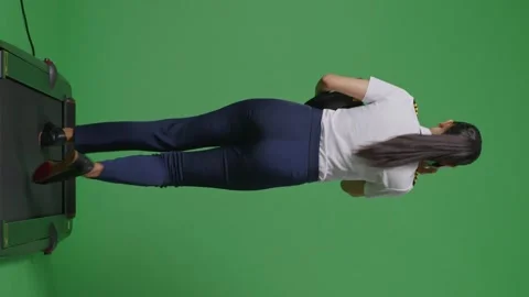 Woman Pilot Talking On Smartphone While Walking On Treadmill In The Green Screen Stock Footage 251687338