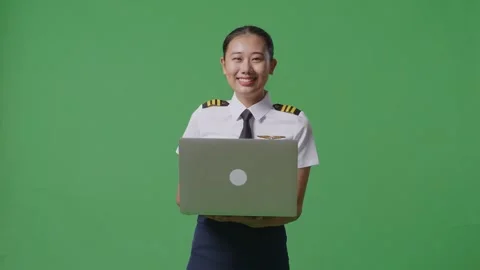 Woman Pilot Using A Laptop And Smiling To Camera While Standing On Green Screen Stock Footage 251641966