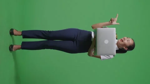Woman Pilot Using A Laptop And Pointing To Side While Standing On Green Screen Stock Footage 251645547