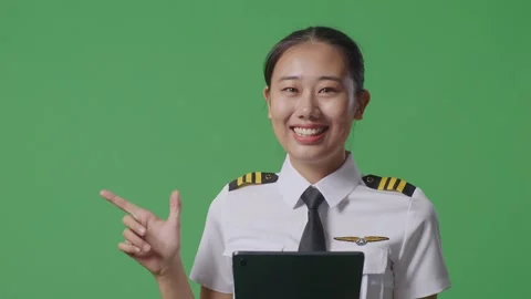 Woman Pilot Using A Tablet And Pointing To Side While Standing On Green Screen Stock Footage 251644073