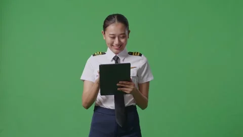 Woman Pilot Using A Tablet While Standing In The Green Screen Background Studio Stock Footage 251642003