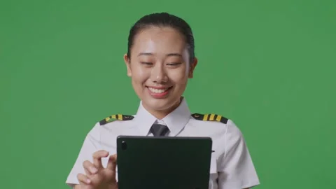 Woman Pilot Using A Tablet While Walking In The Green Screen Background Studio Stock Footage 251685706