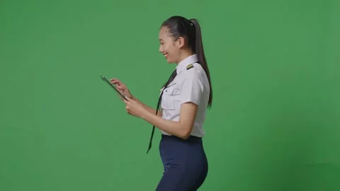 Woman Pilot Using A Tablet While Walking In The Green Screen Background Studio Stock Footage 251686595