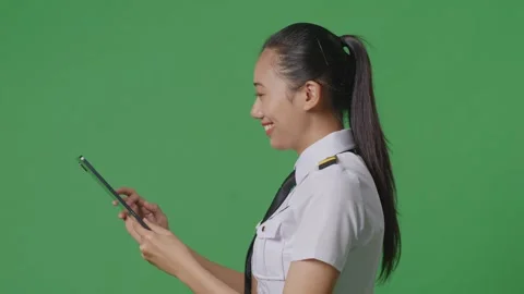 Woman Pilot Using A Tablet While Walking In The Green Screen Background Studio Stock Footage 251686879
