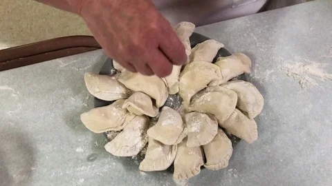 Woman Places Uncooked Pierogies on Dish Stock Footage
