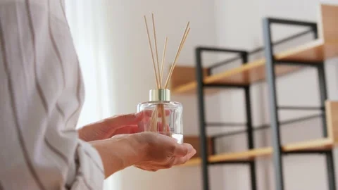Woman placing aroma reed diffuser to shelf home Stock Footage 138447288