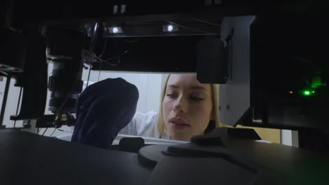 Woman placing sample vials into HPLC system in laboratory Stock Footage 342934737