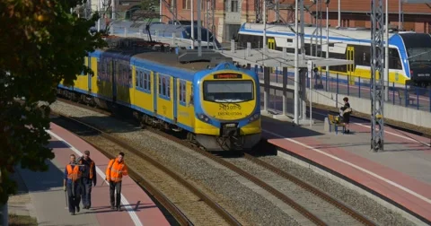 Woman at Platform Train Arrived Workers are Walking Two Blue And Yellow Stock Footage 55293489