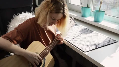 Woman playing guitar, home practice session, acoustic instrument, musical e.. Stock Footage 271663053