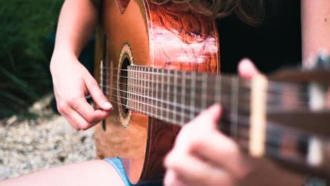 A woman playing a guitar in nature Stock Photos