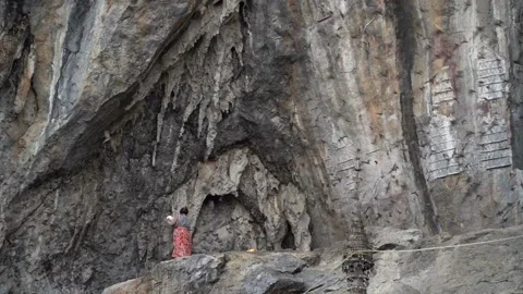 Woman playing an instrument while bats are flying around her at Bat Cave, hpa an Stock Footage 220076835