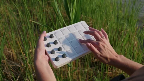 Woman Playing Midi Pad Controller in Tall Green Grass Reeds Outdoors Stock Footage 342771350