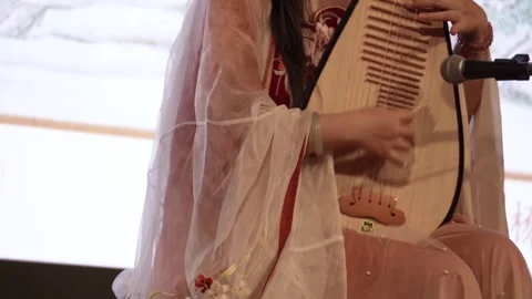 A woman is playing the pipa on the stage. Видео 310821053