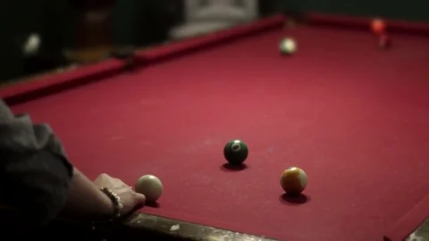 Woman playing pool at pool table hits a ball across table Stock Footage 75355762
